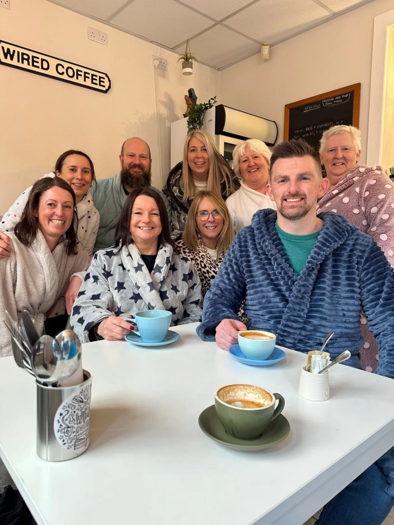 Viral TikTok Sensation Crazy Aunty Ann in Wired Cafe, Honley, with members of Honley Business Association. They are all dressed in their dressing gowns.