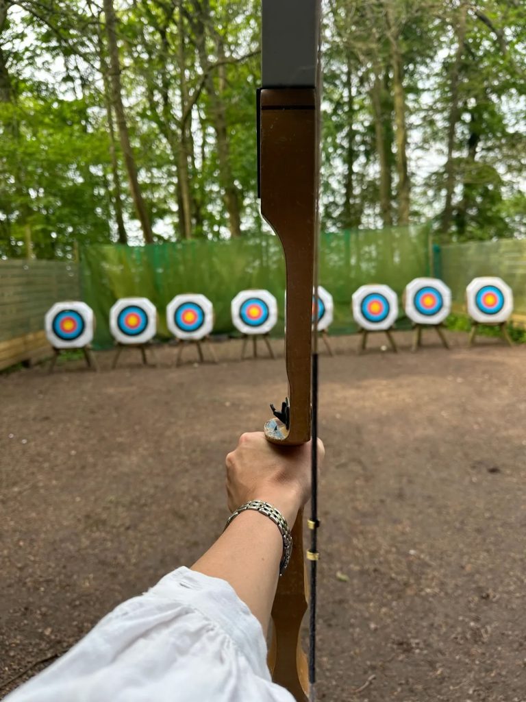 Sophie, of Sophie Seddon PR, holding up a bow and arrow at Live For Today, Hazlewood Castle, Leeds.