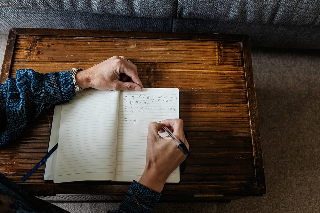 Sophie of Sophie Seddon PR sat at her desk with a notepad and pencil writing in shorthand.